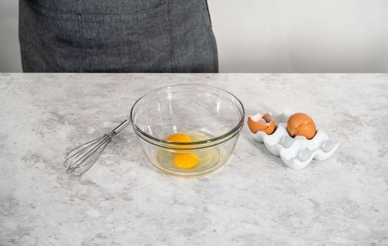 Measured ingredients in glass mixing bowls to bake eggnog scones.
