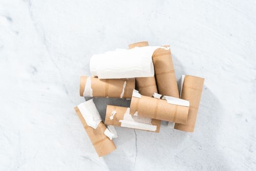 Flat lay. Used empty toilet paper rolls on a gray background.