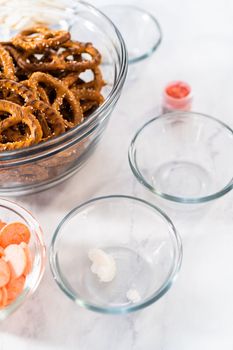 Measured ingredients in glass mixing bowls to prepare chocolate-covered pretzel twist.