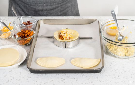 Filling empanada dough with egg filling to make breakfast empanadas with eggs and sweet potato.