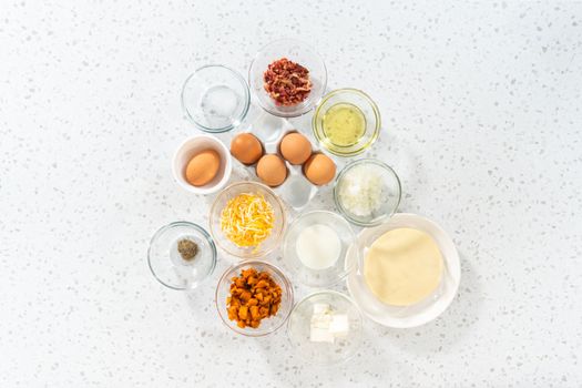 Flat lay. Measured ingredients in glass mixing bowls to make breakfast empanadas with eggs and sweet potato.