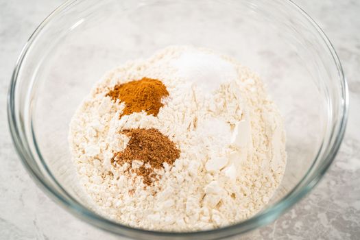 Mixing ingredients in a large glass mixing bowl to bake eggnog scones.