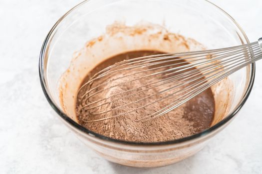 Mixing ingredients in a glass mixing bowl to bake s'mores cupcakes.