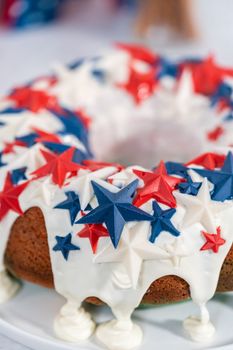 July 4th bundt cake covered with a vanilla glaze and decorated with chocolate stars on a white plate.