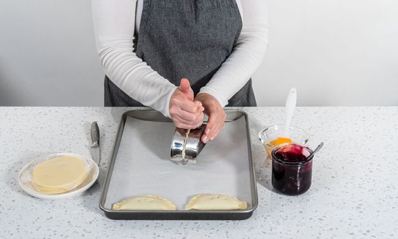 Filling empanada dough with blueberry pie filling to make sweet empanadas with blueberries.