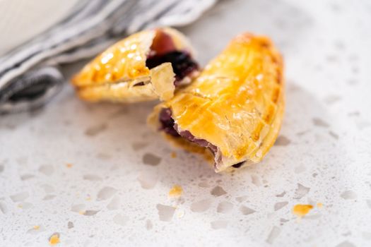 Freshly baked sweet empanadas with blueberries on the kitchen counter.
