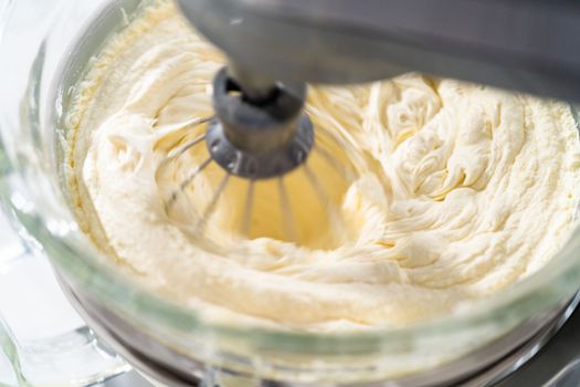 Whipping white ganache in kitchen mixer to make the white chocolate ganache frosting.