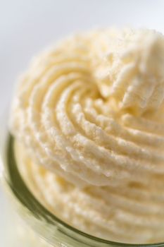 White chocolate ganache frosting in a small glass mason jar.