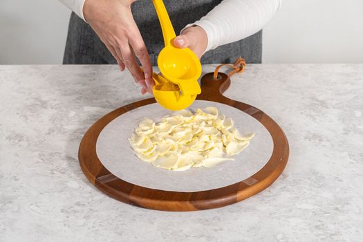 Assembling butter board with vegetables and bread on a round wood cutting board.