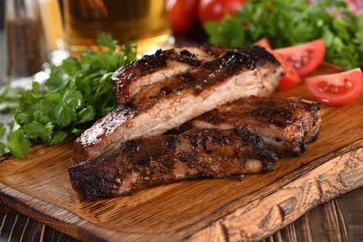 Delicious Baked Grilled Sliced pork belly with barbeque  sauce plating on wooden plate,  herbs and vegetables