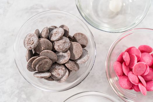 Ingredients in a glass mixing bowls for preparing gourmet mini chocolates with sprinkles.