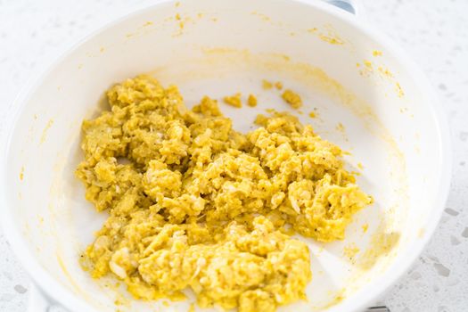 Frying eggs on a nonstick frying pan to make breakfast empanadas with eggs and sweet potato.