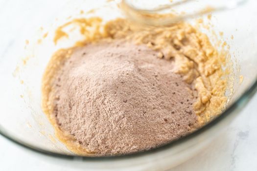 Mixing ingredients in a glass mixing bowl to bake chocolate graham crackers.