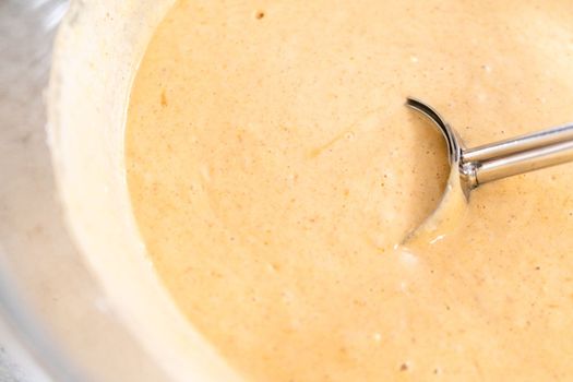 Pumpkin pancakes batter in a glass mixing bowl.