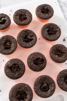 Filling freshly baked chocolate cupcakes with strawberry filling.