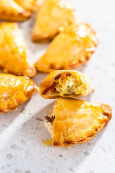 Freshly baked breakfast empanadas with eggs and sweet potato on the kitchen counter.