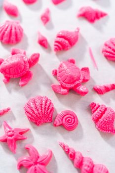 Making sea-shaped chocolates to decorate chocolate-dipped pretzels twists.
