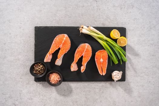 Flat lay. Farm-raised salmon steaks on a slate board.