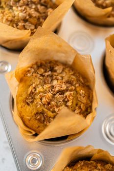 Freshly baked banana oatmeal muffins in a small muffin pan.