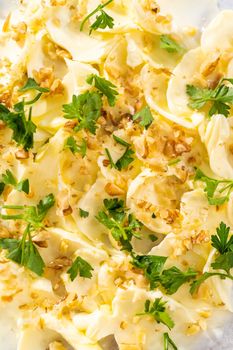 Assembling butter board with vegetables and bread on a round wood cutting board.