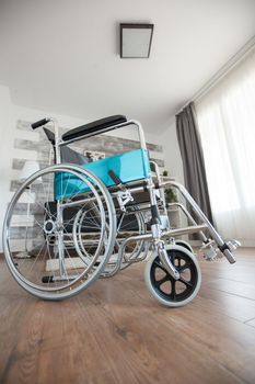 Wheelchair in a room with nobody in it for patients with walking disability. No patient in the room in the private nursing home. Therapy mobility support elderly and disabled walking disability impairment recovery paralysis invalid rehabilitation