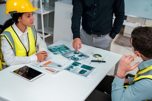 Engineers and competent employer discussing plans and blueprints together with tablet in the office. Concept of team contribution of ideas for engineering project.