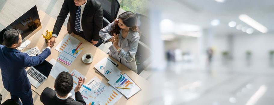 Group business people handshake at meeting table in widen view in office together with confident shot from top view . Young businessman and businesswoman workers express agreement of investment deal.