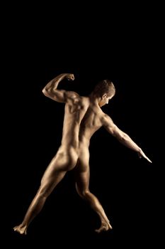 Naked athletic man posing in metallic skin make-up