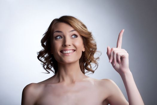 Beauty young woman point finger and smile about smart idea