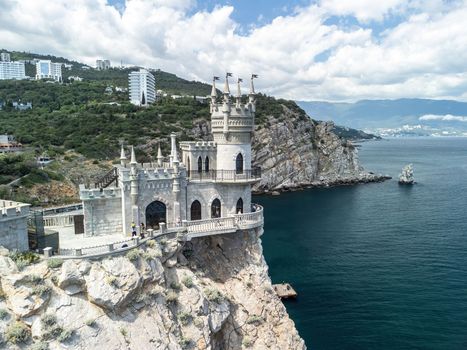Aerial view of Swallow's Nest castle on the rock in Black Sea. It is a symbol and landmark of Crimea. Beautiful scenic panorama of the Crimea coast. Amazing Swallow's Nest at the precipice.