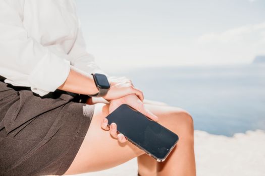 Happy girl doing yoga with laptop working at the beach. beautiful and calm business woman sitting with a laptop in a summer cafe in the lotus position meditating and relaxing. freelance girl remote work beach paradise