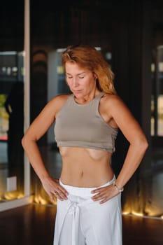 a woman does breathing exercises in the fitness room. Home sports training for the muscles of the press.