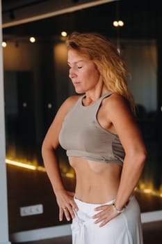 a woman does breathing exercises in the fitness room. Home sports training for the muscles of the press.