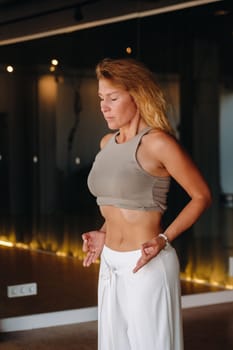 a woman does breathing exercises in the fitness room. Home sports training for the muscles of the press.