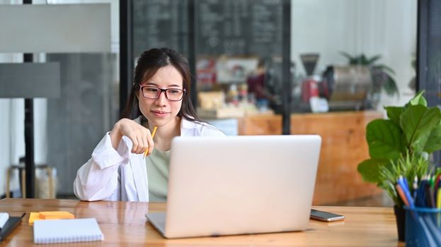 Asian woman freelancer working with computer laptop at cafe.