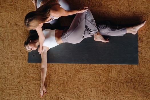 Yoga exercises. A personal trainer teaches a woman yoga classes in the gym.