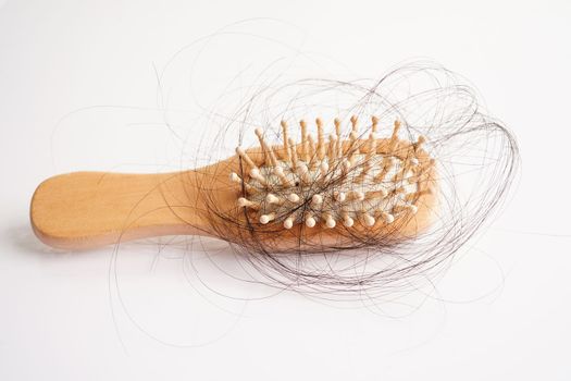 Hair loss fall with comb brush isolated on white background.