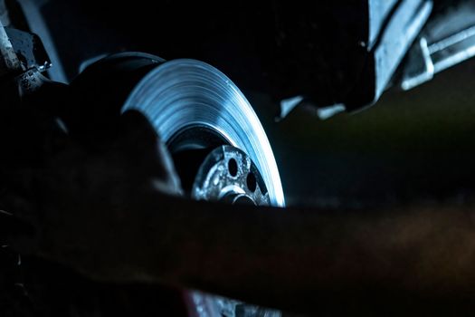 Mechanic hands detail during a maintenance of car brakes