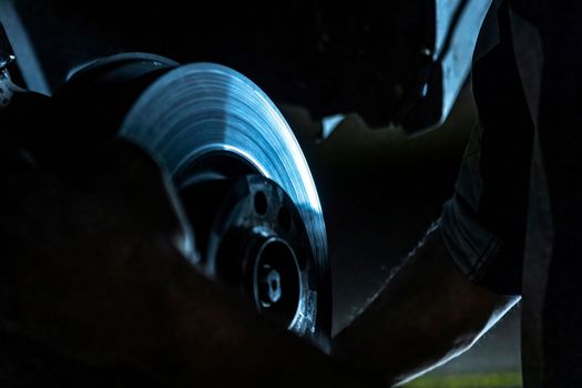 Mechanic hands detail during a maintenance of car brakes