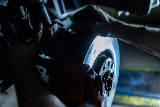Mechanic hands detail during a maintenance of car brakes
