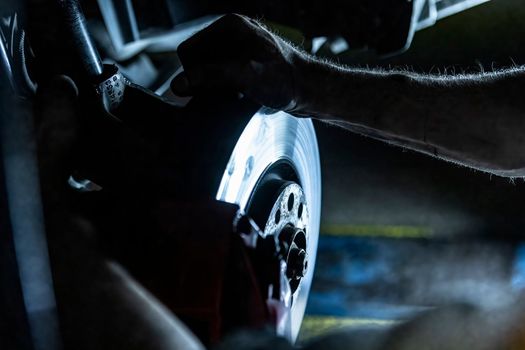 Mechanic hands detail during a maintenance of car brakes