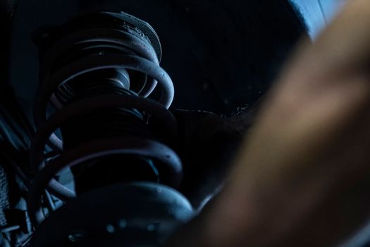 Mechanic hands detail during a maintenance of car suspension