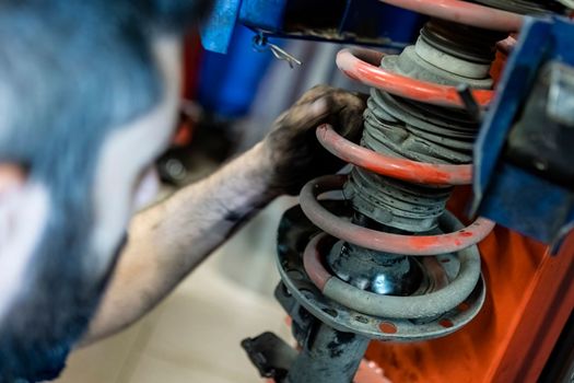 Mechanic hands detail during a maintenance of car suspension