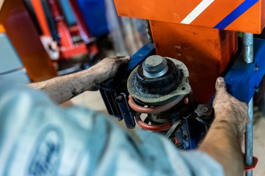 Mechanic hands detail during a maintenance of car suspension