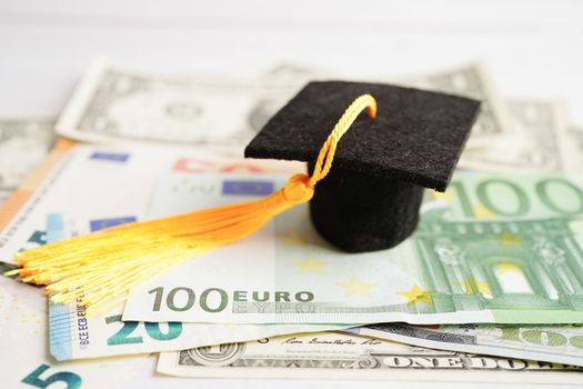 Graduation gap hat on Euro and US dollar banknotes money, Education study fee learning teach concept.