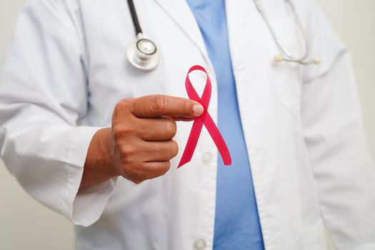 Asian woman doctor with pink ribbon, World Breast Cancer Day at October.