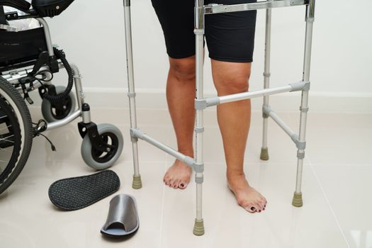 Asian woman injury from falling down on slippery surfaces with walker at home.