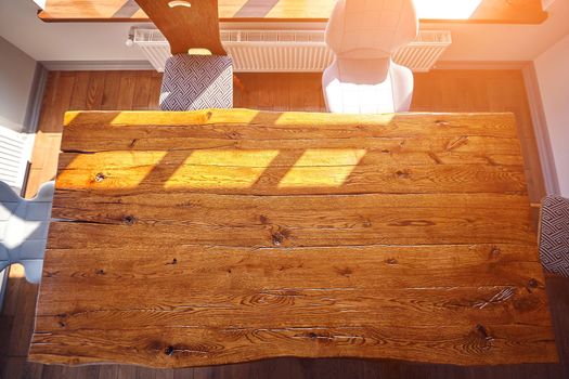 Top view of dining wooden table at the kitchen. Copy space. Sun rays from the window