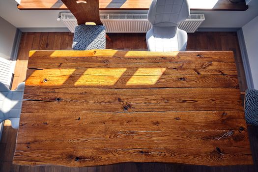 Top view of dining wooden table at the kitchen. Copy space. Sun rays from the window