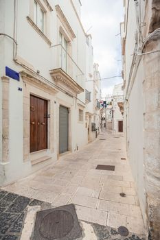 Beautiful view of an empty streets of old town Martina Franca with an ancient houses painted in white. Wonderful day in a tourist town, Apulia, Italy.